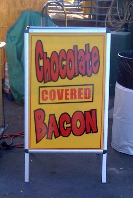 A sign advertising chocolate covered bacon.